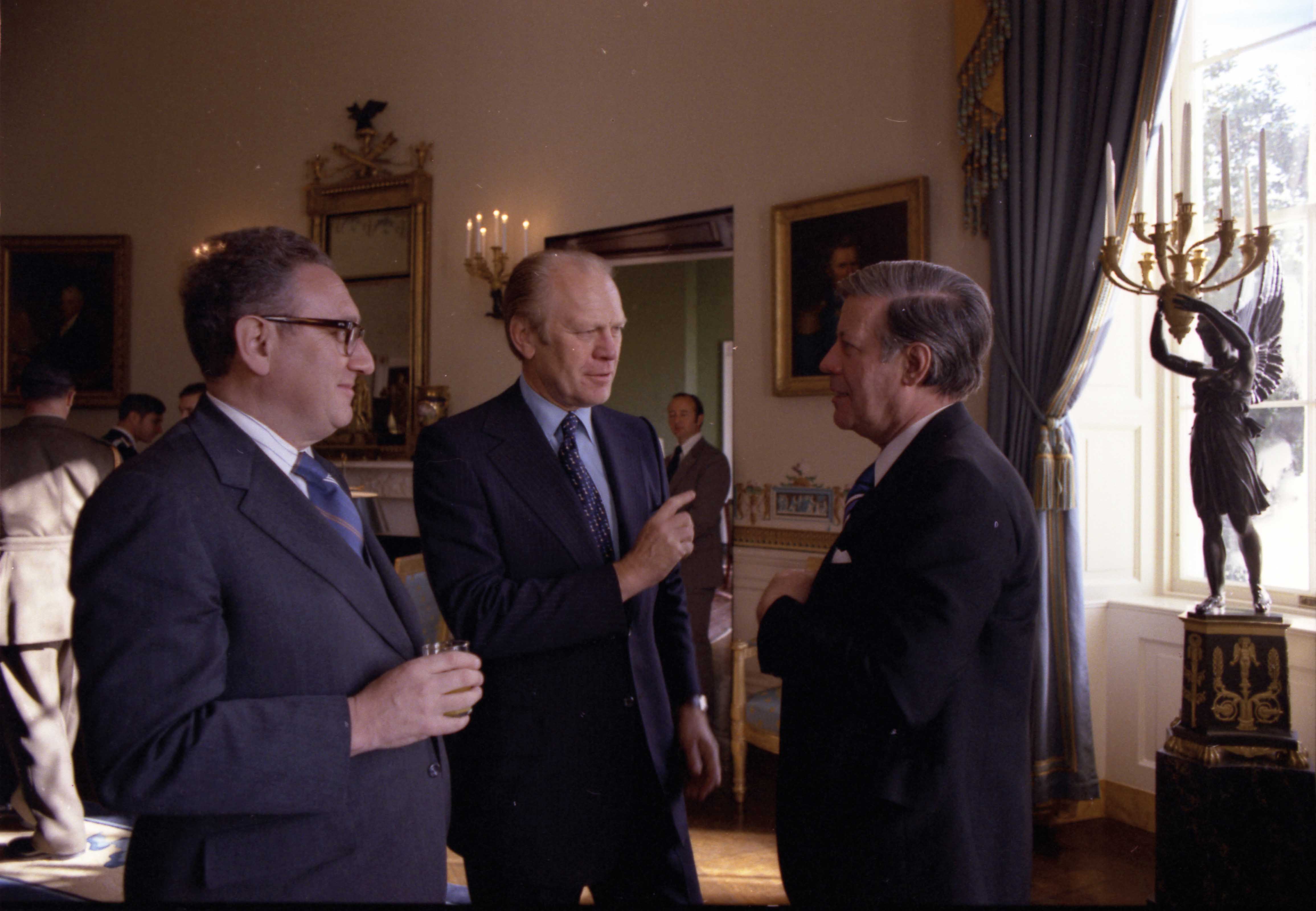 photograph_of_secretary_of_state_henry_kissinger_president_gerald_r._ford_and_chancellor_helmut_schmidt_of_the_federal_republic_of_germany_talking_in_the_blue_room_at_a_reception_following_the_state_arrival_cere..._-_nara_-_7462079.jpg